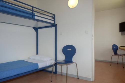 a bedroom with a bunk bed and two chairs at ibis budget Nevers Varennes Vauzelles in Varennes Vauzelles