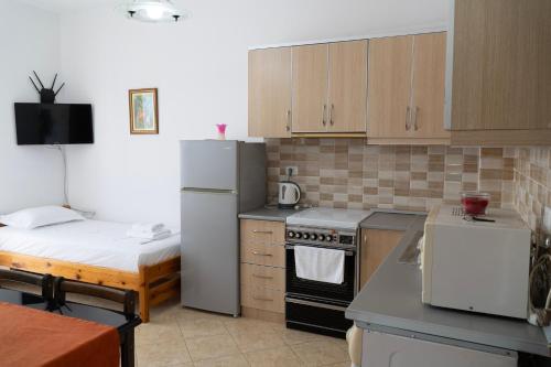 a kitchen with a refrigerator and a bed in it at Parid Appartments in Sarandë