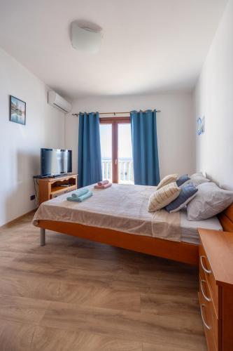 ein Schlafzimmer mit einem großen Bett und blauen Vorhängen in der Unterkunft Adrian in Rafailovici