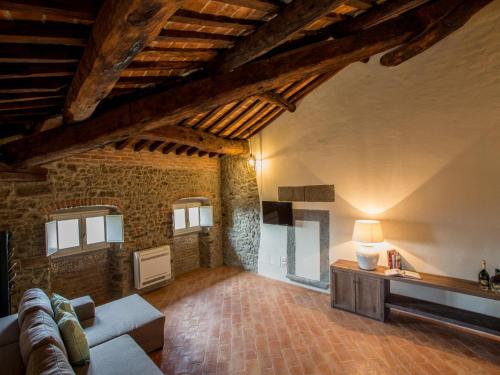 a living room with a couch and a brick wall at Casa Zeni in Cortona