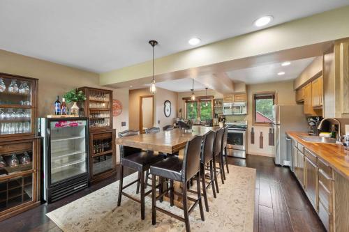 a large kitchen with a wooden table and chairs at Walk to Lift Across from Holiday Valley AC in Ellicottville
