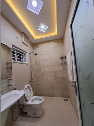 a bathroom with a toilet and a sink and a shower at Regal Horizon G-13 in Islamabad
