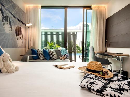 a bedroom with a bed with a hat on it at Novotel Brisbane South Bank in Brisbane
