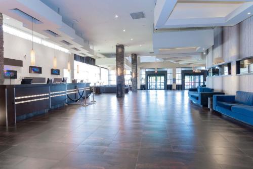 a lobby with blue couches in a building at Sandman Signature Vancouver Airport Hotel & Resort in Richmond