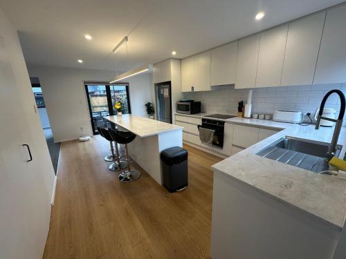 a kitchen with white cabinets and a counter top at Airport Retreat 4 Bedrooms 8 Guests in Christchurch
