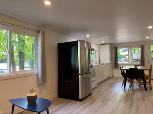a kitchen with a stainless steel refrigerator and a table at Camping Chalets Lac St-Augustin in Quebec City