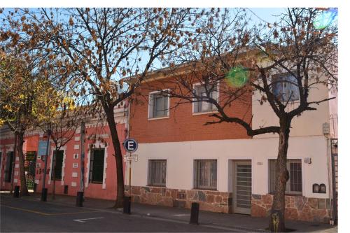 a building on the side of a street with trees at Hostel en Córdoba Capital con excelente ubicación y ambiente cuidado -Casa Revol- Barrio Güemes in Cordoba