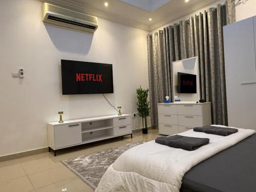 a bedroom with two beds and a television on the wall at Brand new - Stylish Studio Near to Yas & Airport in Abu Dhabi