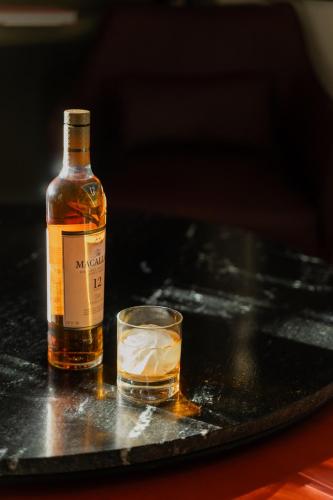 a bottle of whisky and a glass on a table at Kahal Hotel - Paseo Montejo in Mérida