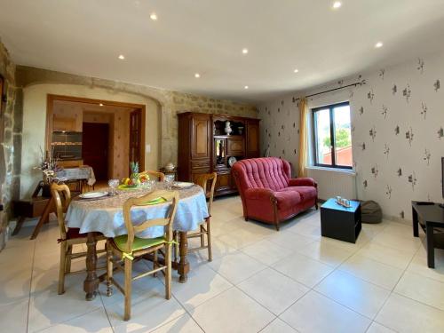 un salon avec une table et une chaise rouge dans l'établissement Charmante maisonnette à Blavozy, proche du Puy-en-Velay, avec terrasse privative, WiFi, et parking - FR-1-582-57, à Blavozy