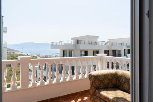 a chair on a balcony with a view of a building at Parid Appartments in Sarandë
