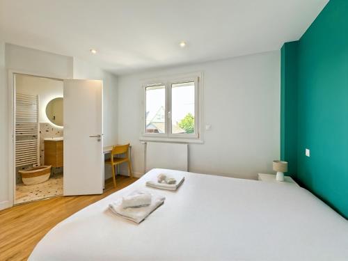 une chambre avec un lit blanc et un mur vert dans l'établissement Le Céleste - Élégance raffinée - Terrasse - Plages, à Saint-Malo