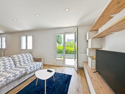 un salon avec un canapé et une table dans l'établissement Le Céleste - Élégance raffinée - Terrasse - Plages, à Saint-Malo