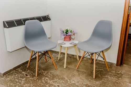 two chairs and a table in a room at Akrata studio in Paralía Akrátas