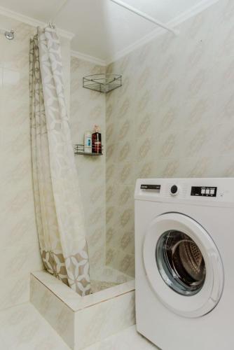 a washing machine in a bathroom with a shower at Akrata studio in Paralía Akrátas