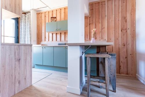 une cuisine avec des armoires bleues et une table dans l'établissement T3 bien situe a La Teste proche d Arcachon, à La Teste-de-Buch
