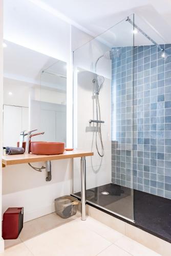 La salle de bains est pourvue d'une douche, d'une table en bois et d'un lavabo. dans l'établissement T3 bien situe a La Teste proche d Arcachon, à La Teste-de-Buch