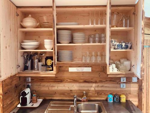 La cuisine est équipée d'un évier et d'une armoire remplie de vaisselle. dans l'établissement B2 Superbe apart Ski au pied Vue magnifique, à Huez