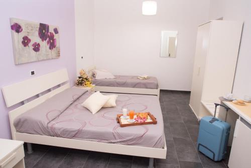 - 2 lits dans une chambre avec un plateau de nourriture dans l'établissement B&b Meta Mito, à Budoni