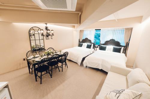 a bedroom with two beds and a table and chairs at MONTHLIV Euljiro Hotel Stay in Seoul