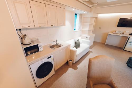 a small kitchen with a sink and a washing machine at MONTHLIV Euljiro Hotel Stay in Seoul