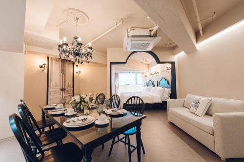 a dining room and living room with a table and a couch at MONTHLIV Euljiro Hotel Stay in Seoul