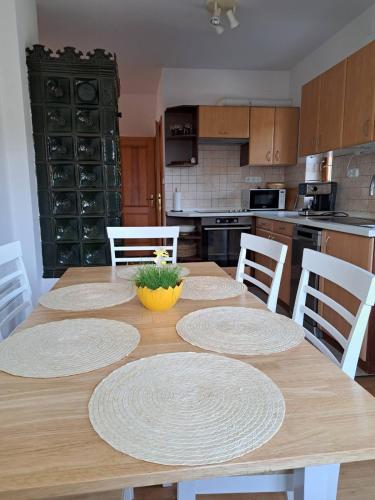 a kitchen with a wooden table with white chairs at Öreghegyi Vendégház - Guesthouse on the Old Hill in Balatonszepezd