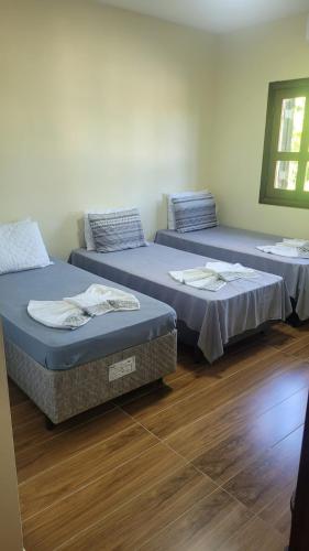 two beds sitting in a room with wooden floors at LM Hotel Araçatuba in Araçatuba