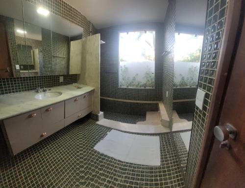 a bathroom with a sink and a shower and a window at LM Hotel Araçatuba in Araçatuba