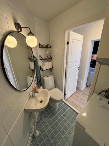 a bathroom with a sink and a mirror and a toilet at Historic SELF-SERVICE apartment in downtown Vaasa in Vaasa