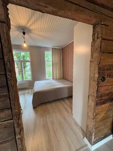 a bedroom with a bed and two windows at Historic SELF-SERVICE apartment in downtown Vaasa in Vaasa