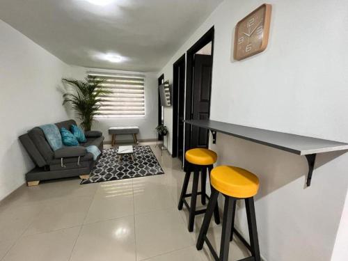 a living room with a counter and two stools at Apartamento confortable y tranquilo in Manizales
