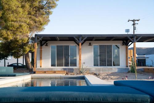 a house with a swimming pool in front of it at Hi Desert Pool Club in Landers