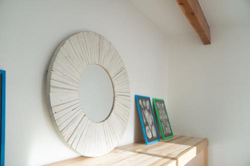 a mirror on a wall next to a shelf with pictures at Hi Desert Pool Club in Landers