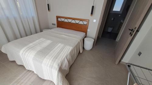 a bedroom with a bed with a white comforter at Arsinoe Villa in Kouvaláta