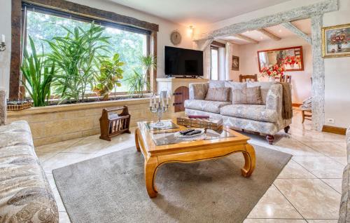 un salon avec un canapé et une table dans l'établissement 3 Bedroom Gorgeous Home In Le Lardin, à La Villedieu