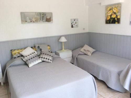 - deux lits jumeaux dans une chambre avec deux tables dans l'établissement Holiday Home in Piolenc near Roman Orange, cleaning included, à Piolenc