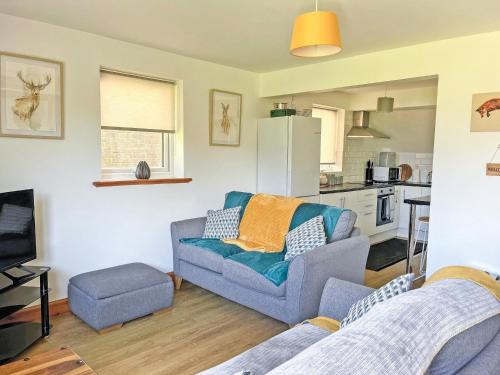 a living room with a couch and a kitchen at Sheep's View Cottage in Eastbourne