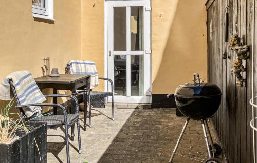 a grill on a patio with a table and chairs at Beautiful Apartment In Skagen With Wifi in Skagen
