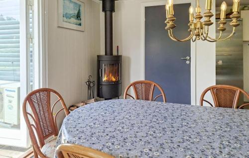 a dining room with a table and a wood stove at 3 Bedroom Gorgeous Home In Blåvand in Blåvand