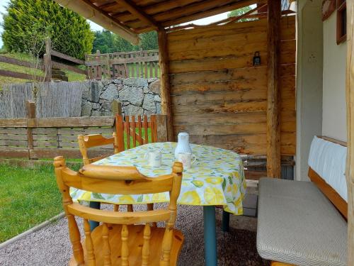 une table et des chaises sur une terrasse avec une clôture dans l'établissement Chalet in Vosges near Rouge Gazon Ski Resort, cleaning included, à Saint-Maurice-sur-Moselle
