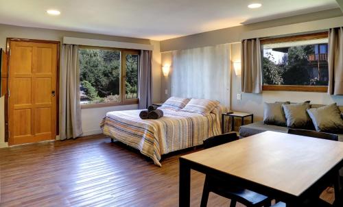 una camera da letto con un letto, un tavolo e un divano di Las Liebres a San Carlos de Bariloche