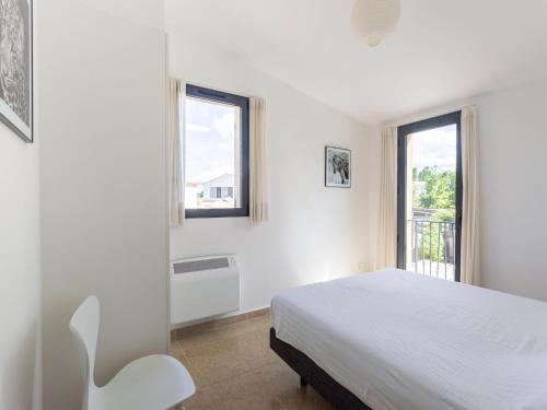 une chambre blanche avec un lit et deux fenêtres dans l'établissement Villa in Malaucène with Mont Ventoux Views, cleaning included, à Malaucène