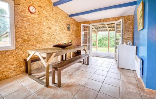 une cuisine avec une table en bois et un réfrigérateur dans l'établissement Charmante Maison À La Campagne, à Bourg-du-Bost