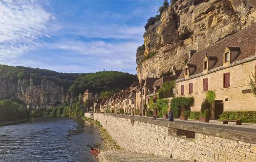a street next to a river next to a mountain at Stunning Home In Plazac With Wifi in Plazac