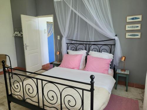 une chambre avec un lit avec des oreillers roses et blancs dans l'établissement Holiday Home in Limousin near Forest, cleaning included, à Sainte-Anne-Saint-Priest