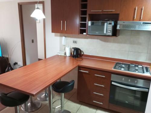 cocina con encimera de madera y mesa de madera en Apartamento en Iquique, en Iquique