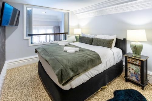a bedroom with a large bed and a window at Cathedral Square Apartment 2 bed in Christchurch
