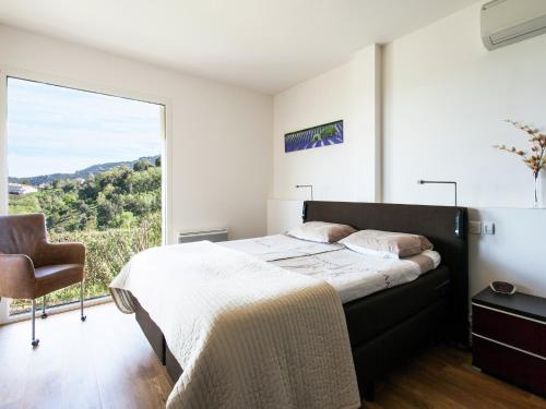 une chambre avec un lit et une grande fenêtre dans l'établissement Villa in Varl with Pool and Hill Views, cleaning included, à Les Adrets-de-l'Estérel