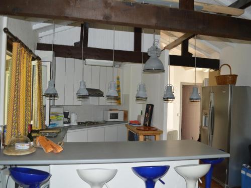 une cuisine avec un comptoir et quelques tabourets bleus dans l'établissement Fayence Villa with Private Pool, cleaning included, à Fayence